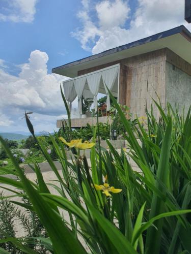 ein Haus am Strand mit Blumen im Vordergrund in der Unterkunft เฌอปือ เชียงใหม่ Cherpue Chiangmai 