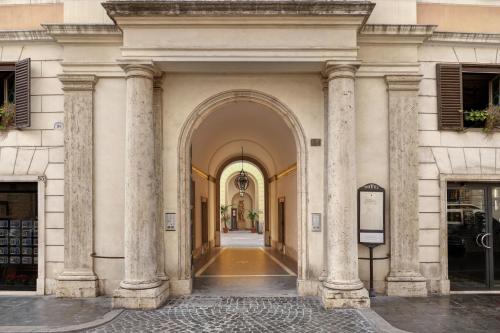 einen Torbogen in einem Gebäude mit Säulen in der Unterkunft Borghese Contemporary Hotel in Rom