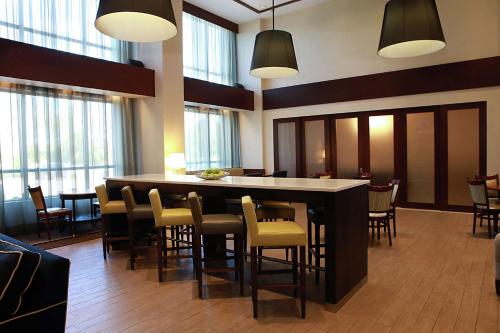 - un hall doté d'un bar avec des chaises et des fenêtres dans l'établissement Hampton Inn & Suites Laval, à Laval