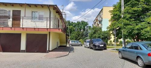 una strada con auto parcheggiate sul lato di un edificio di Kwatera Mikołajki a Mikołajki