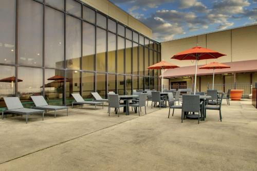 a cafeteria with tables and chairs and umbrellas in front of a building at Doubletree By Hilton Mt. Vernon in Mount Vernon