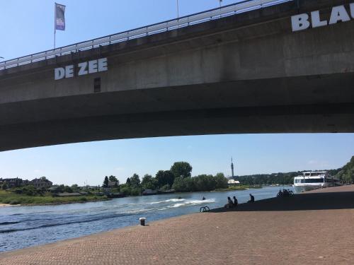 uma ponte sobre um rio com pessoas a andar debaixo dele em Medina B&B hartje Arnhem em Arnhem