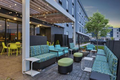 a patio with couches and tables and chairs at Home2 Suites By Hilton Holland in Holland