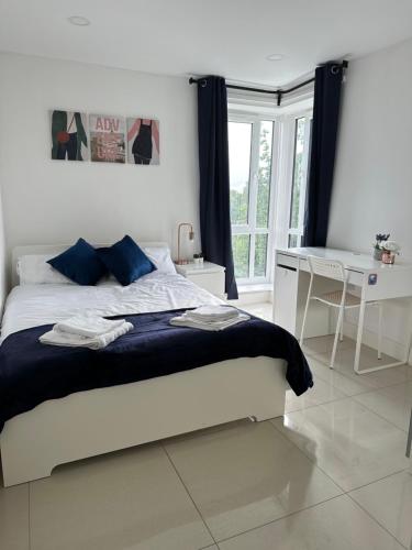 Habitación blanca con cama y escritorio en 3 Bed Cozy Apartment - next to Leeds City Centre & University, en Headingley