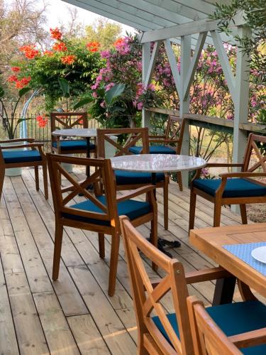 een rij tafels en stoelen op een terras met bloemen bij Nisaki Mathraki B&B in Corfu-stad