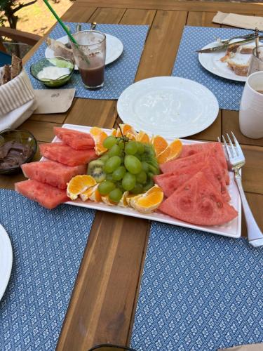 een tafel met een bord watermeloendrank en sinaasappels bij Nisaki Mathraki B&B in Corfu-stad