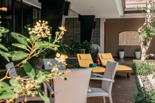 une terrasse avec une table, des chaises et des plantes dans l'établissement Villa 62 Jimbaran, à Jimbaran