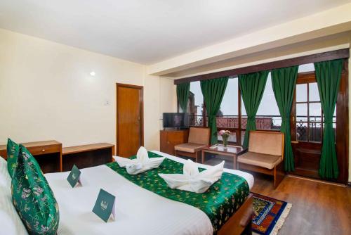 a hotel room with two beds with green covers at Muscatel BhumSang - 200 Mts from Mall Road in Darjeeling