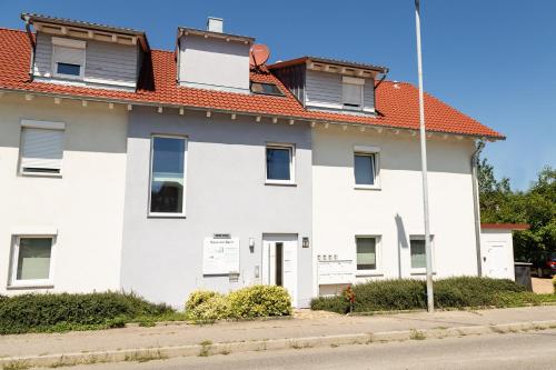 una casa blanca con techo naranja en Braviscasa - Ferienresidenz Haus am Bach Vogtsburg am Kaiserstuhl, en Vogtsburg