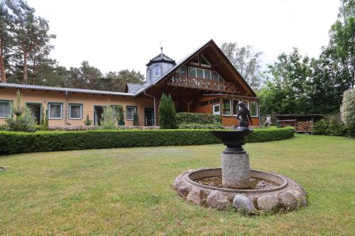 a statue in the middle of a yard in front of a house at Villa-Pälitzsee in Rheinsberg