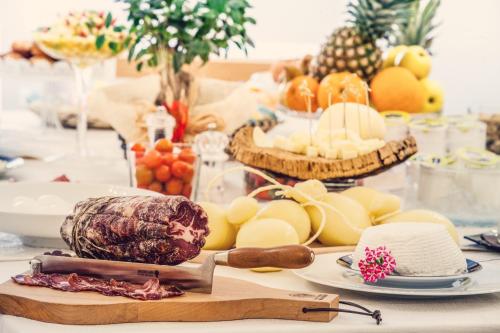 una tavola ricoperta di formaggio, frutta e verdura di Hotel Il Duomo PHG a Oristano