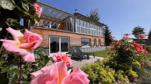 une maison avec un banc et des fleurs devant elle dans l'établissement CR25 - more than a room, à Immenstadt