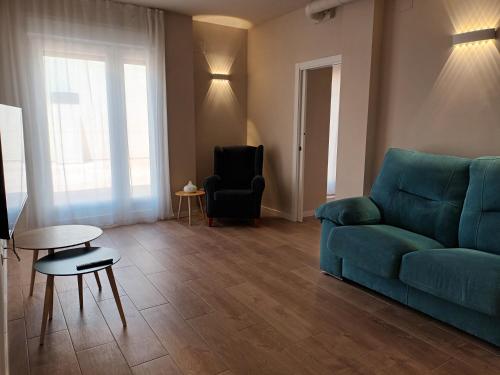 a living room with a blue couch and a table at La Casona del Eboni in Alcalá de Henares