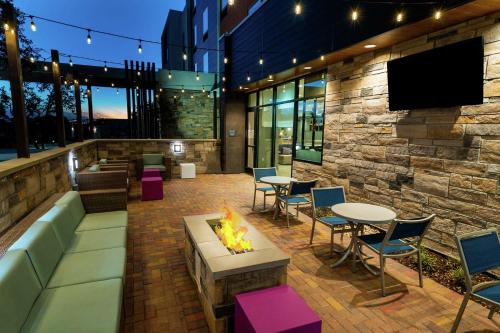 d'une terrasse avec un foyer extérieur, des tables et des chaises. dans l'établissement Hilton Garden Inn Cedar Park Austin, à Austin