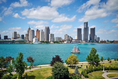 a sailboat on the water in front of a city at DoubleTree by Hilton Windsor, ON in Windsor