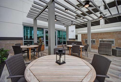 una zona pranzo con tavoli e sedie in un edificio di Home2 Suites by Hilton Houston Medical Center, TX a Houston