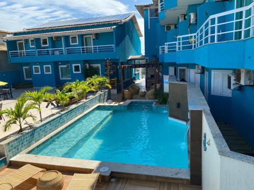 uma piscina em frente a um edifício azul em Pousada Mirante da Prainha em Arraial do Cabo