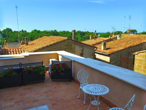 a patio with a table and chairs on a balcony at Neoclassico by Tiziana Monaldi in Pitigliano