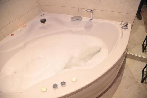 a white bath tub in a bathroom at Jacuzzi Apartman De Lux - Cacak in Čačak