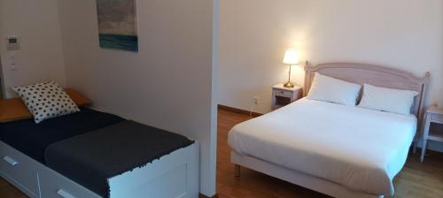 um pequeno quarto com uma cama branca e uma saia-cama preta e branca em Médicis Home Strasbourg em Estrasburgo