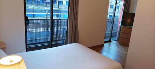 um quarto com uma cama e uma grande janela em Médicis Home Strasbourg em Estrasburgo