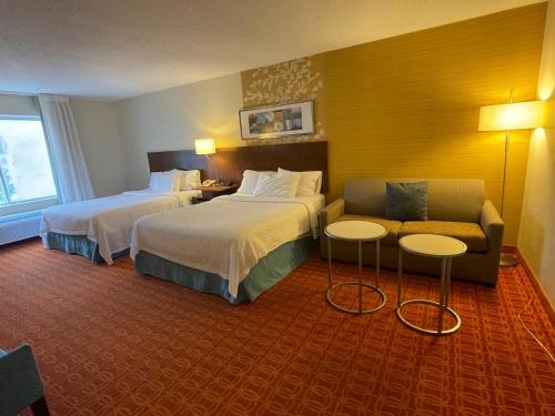 a hotel room with two beds and a couch at Fairfield Inn and Suites by Marriott Potomac Mills Woodbridge in Woodbridge