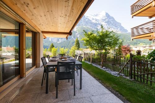 stół na patio z widokiem na góry w obiekcie The Terrace Apartment - GRINDELHOMES w mieście Grindelwald