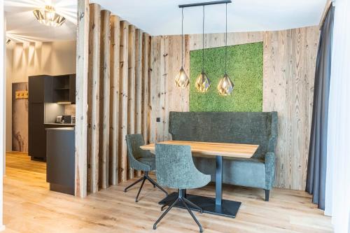 a table and chairs in a room with wooden walls at Zillertal Suites Fügen by ALPS RESORTS in Fügen