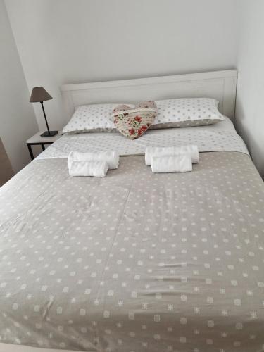 un letto bianco con due cuscini sopra di Apartment Rose a Sesvete