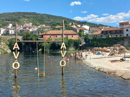 un grupo de personas en el agua en una playa en Quinta da Tapada, en Avô