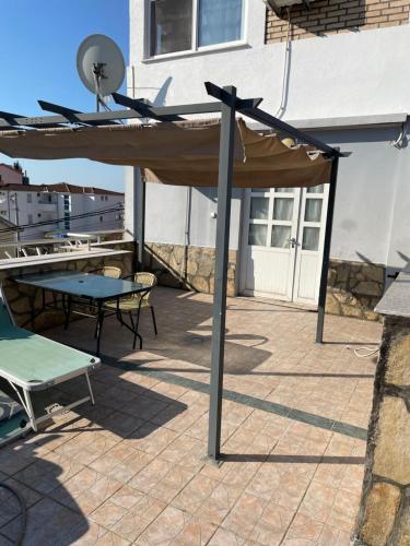 einen Holzschirm auf einer Terrasse mit einem Tisch in der Unterkunft Apartments Sunpoint in Ulcinj