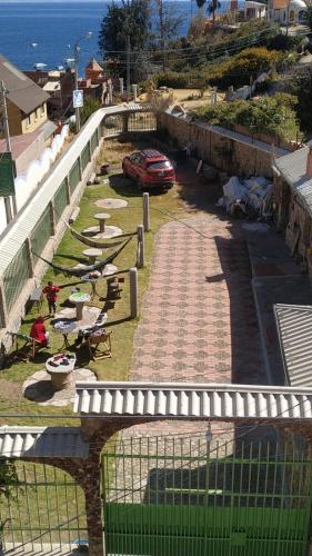 um carro está estacionado num quintal ao lado do oceano em Cabañas Utama em Copacabana