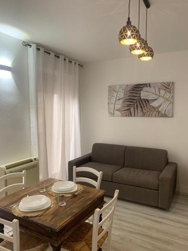 uma sala de estar com uma mesa e um sofá em CagliariParadiseApartment it Marina em Cagliari