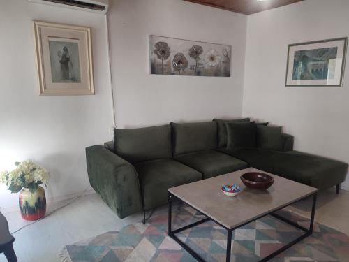 a living room with a green couch and a table at Apartment Mejdan in Mostar