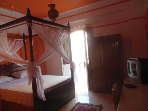 - une chambre avec un lit à baldaquin et une fenêtre dans l'établissement Cleopatra Hotel Luxor, à Louxor