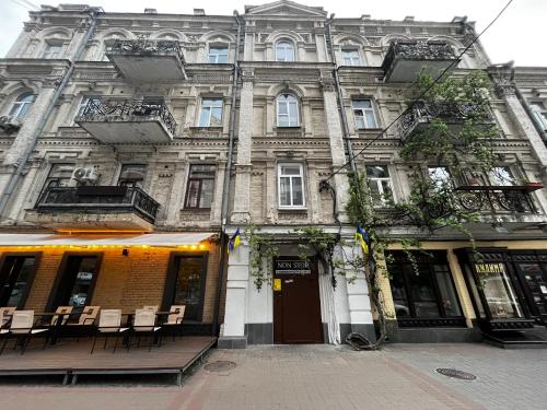 un ancien bâtiment avec des chaises et des tables devant lui dans l'établissement Mini hotel Non-Stop, à Kiev