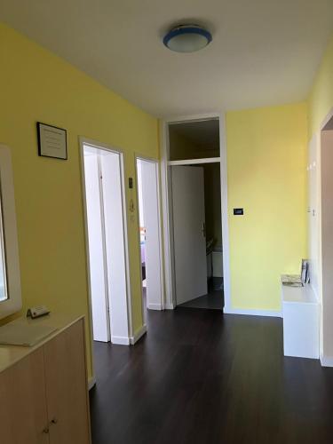 een lege kamer met gele muren en houten vloeren bij Apartment T&M Zagreb Airport in Velika Gorica