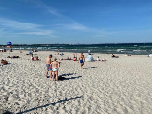 eine Gruppe von Menschen an einem Sandstrand in der Unterkunft Modernes Apartment an Timmendorfer Promenade, 1. Reihe in Timmendorfer Strand