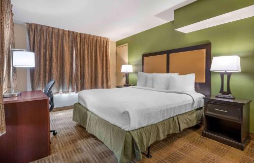 um quarto de hotel com uma cama e uma secretária com dois candeeiros em Extended Stay America Suites - Indianapolis - Northwest - I-465 em Indianápolis