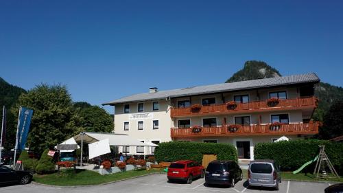 un bâtiment avec des voitures garées dans un parking dans l'établissement Hotel-Restaurant Stefanihof, à Fuschl am See