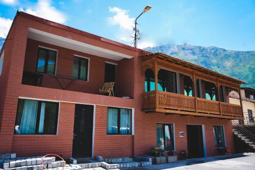 - un bâtiment en briques rouges avec un balcon dans l'établissement Fiten house, à Kazbegi