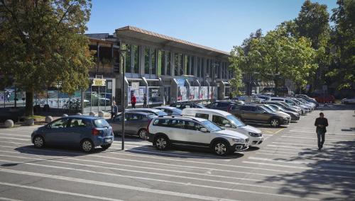 una fila di auto parcheggiate in un parcheggio di M Hotel a Lubiana