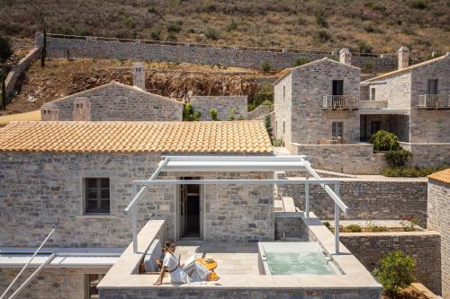 a woman standing on the roof of a house at Trapela Limeni Luxury Suites in Limeni