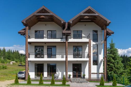 une grande maison blanche avec un toit dans l'établissement Chillax, à Bukovel