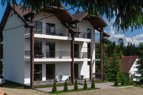 un grand bâtiment blanc avec un toit marron dans l'établissement Chillax, à Bukovel