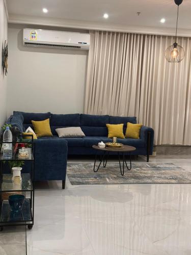 sala de estar con sofá azul y mesa en شقة عائلية خاصة مفروشة في الخبر 1, en Al Khobar