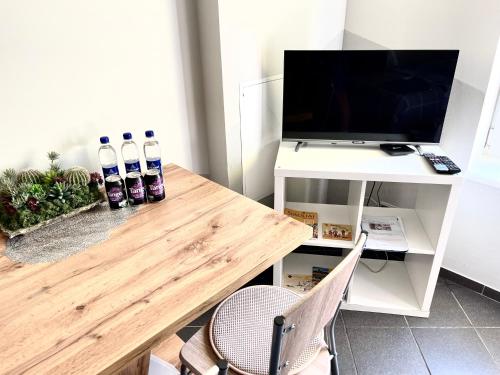 - un salon avec une table en bois et une télévision dans l'établissement Šiauliu apartamentai, à Šiauliai