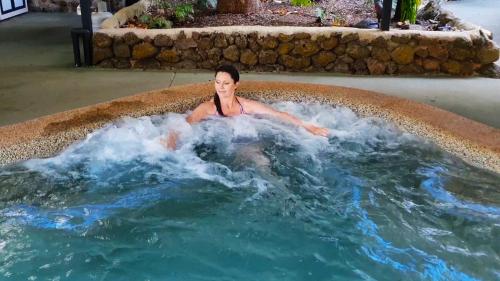 een vrouw ligt in een bubbelbad bij Chambers Wildlife Rainforest Lodges in Lake Eacham