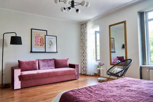 a living room with a pink couch and a bed at Best Apartments on Kyryla & Mefodia in Mukacheve