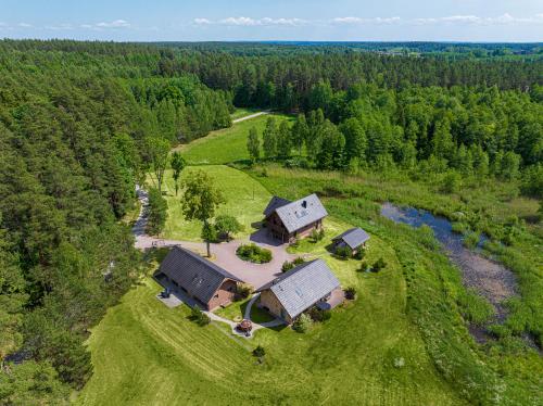 een luchtzicht op een huis in een veld naast een rivier bij Harmony Park Countryside Villas & SPA in Prienai